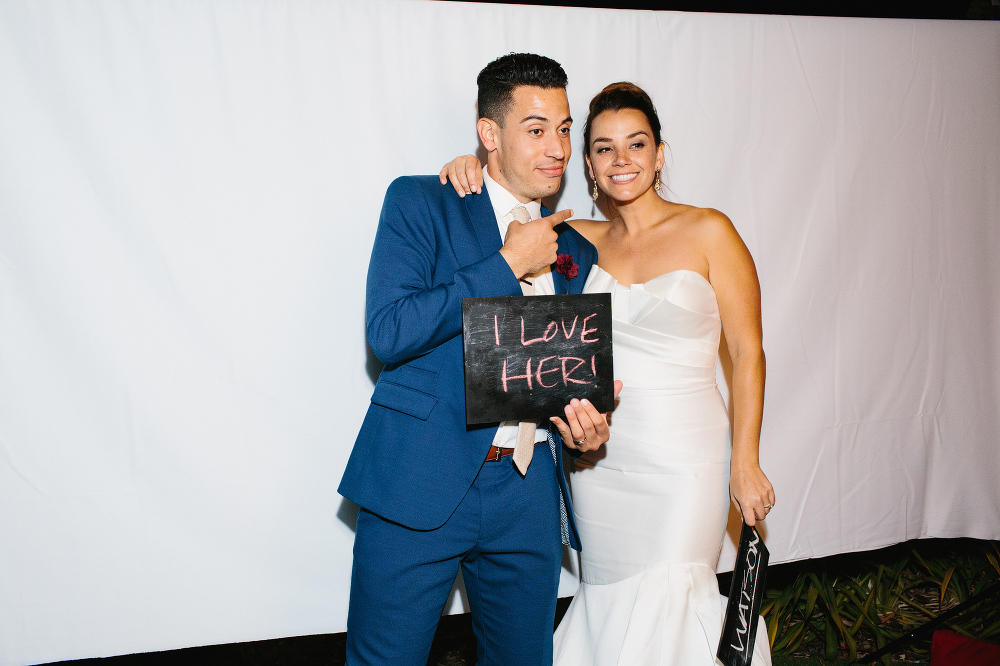 This is a photo of Christina and Mike using a photobooth at their reception. 