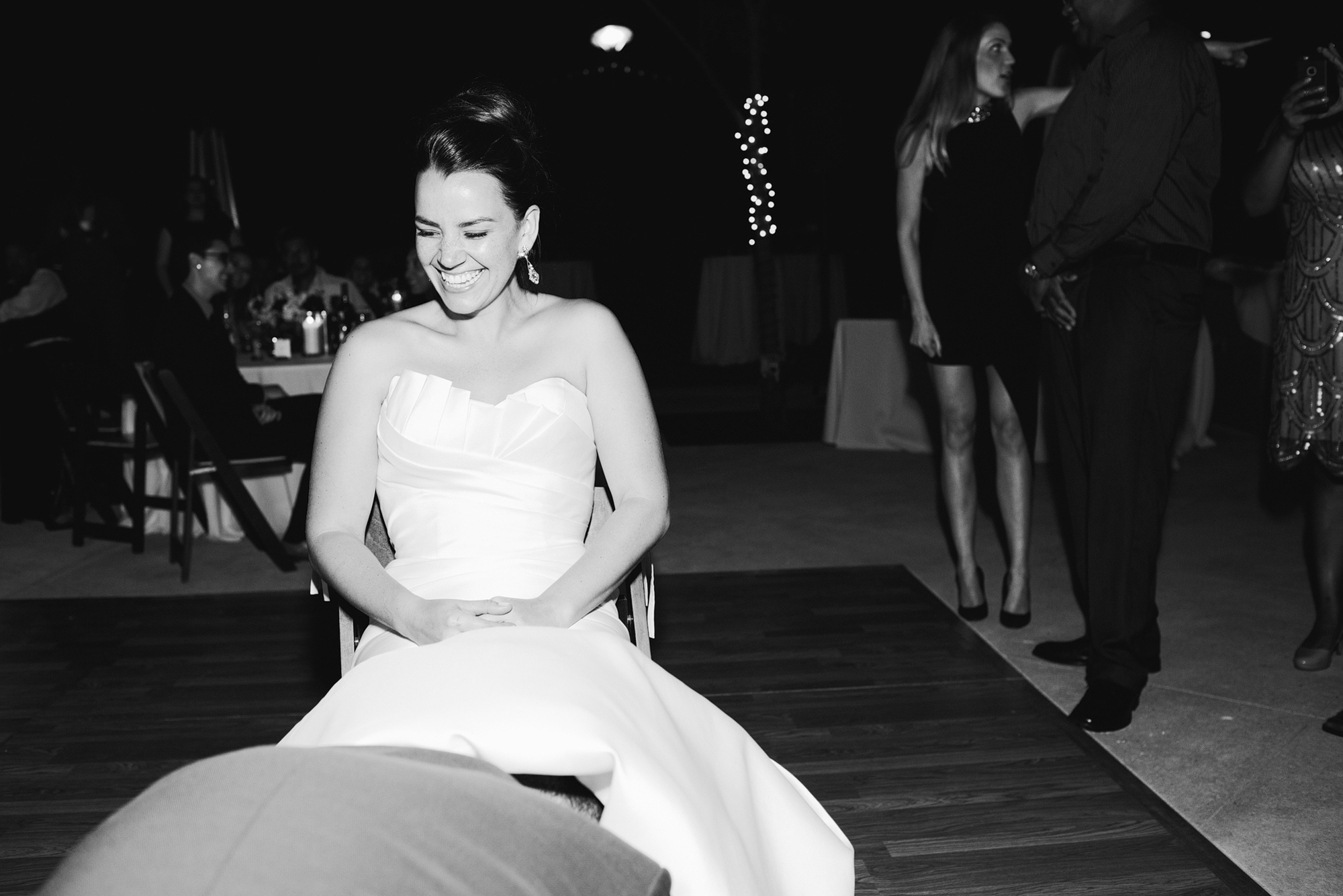 This is a black and white photo of the garter toss. 