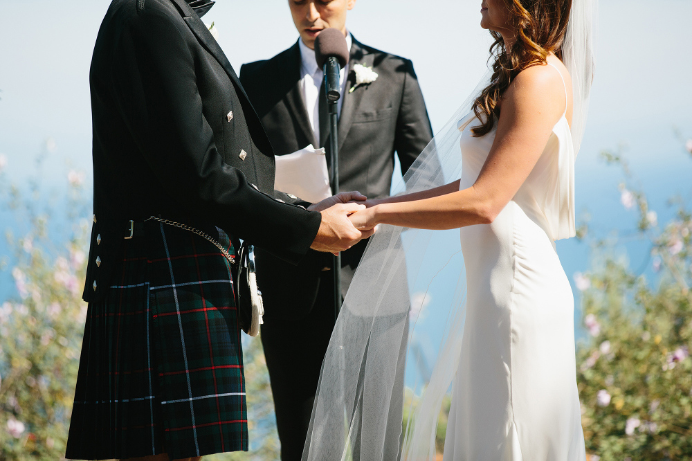 Jessica and Colin holding hands during the wedding ceremony. 