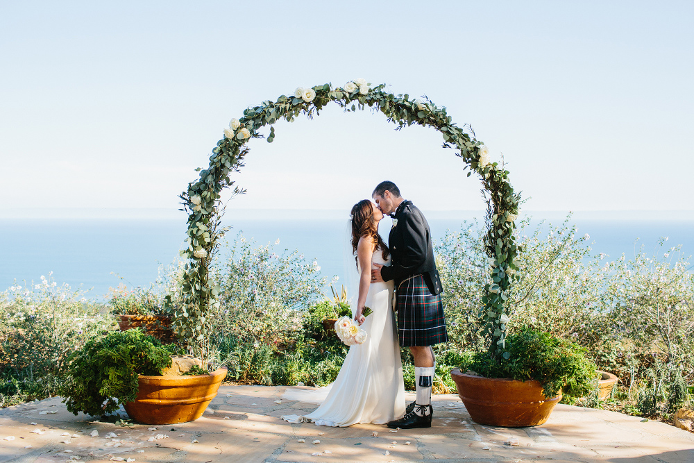 The bride and groom under the ceremony arch. 