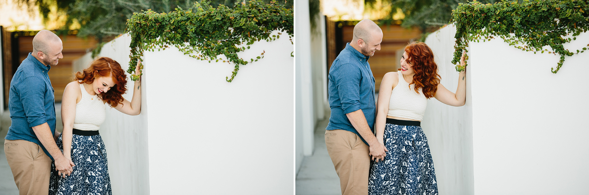 Afton and Jesse taking photos by a white wall with greenery. 