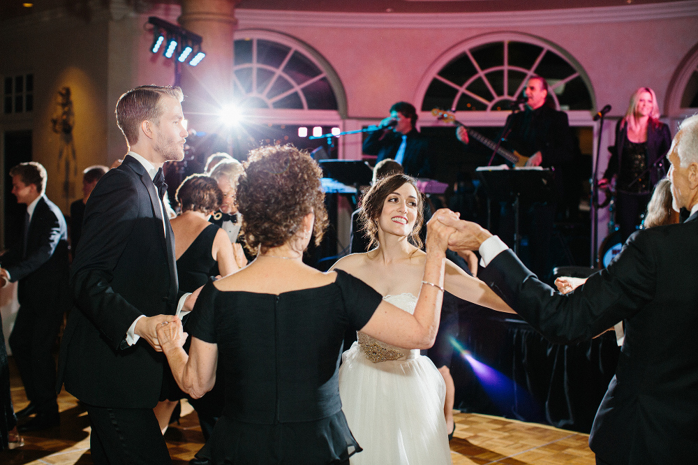 The bride and groom dancing with her parents. 