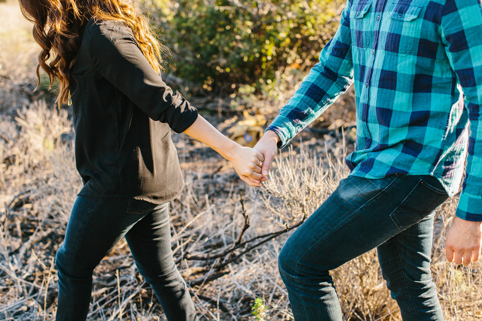 The couple holding hands walking together. 