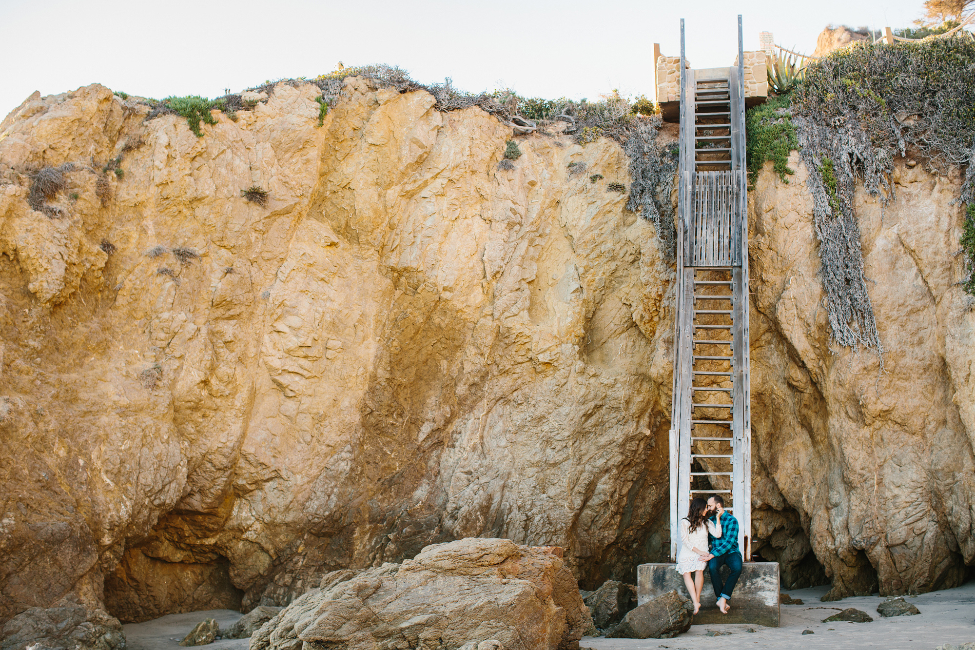 The couple sitting by the cliffside. 