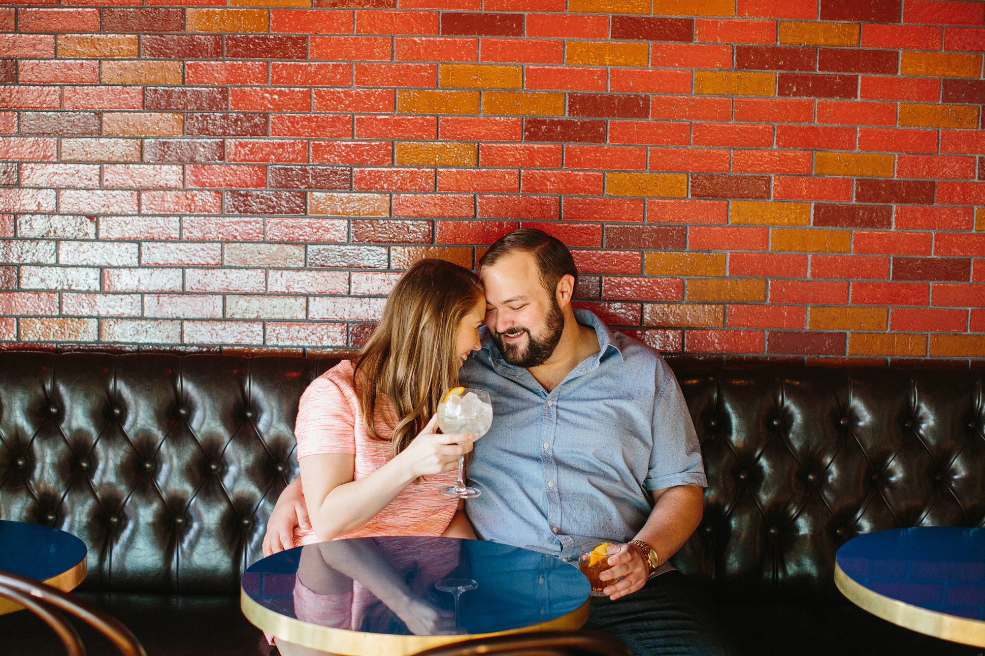 The couple laughing together on the bench. 