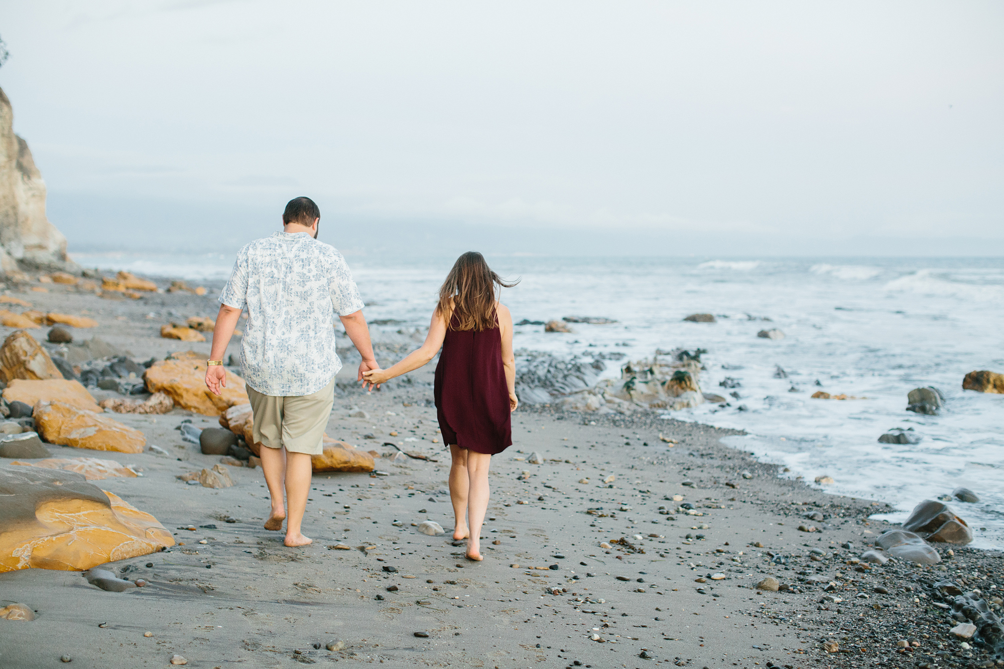 Sarah and Andrew walking together on the beach. 