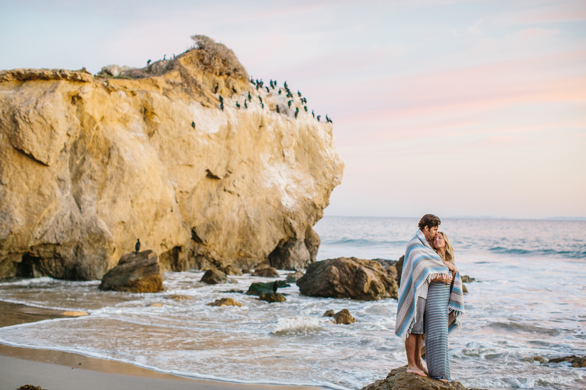 The couple wrapped in a blanket. 